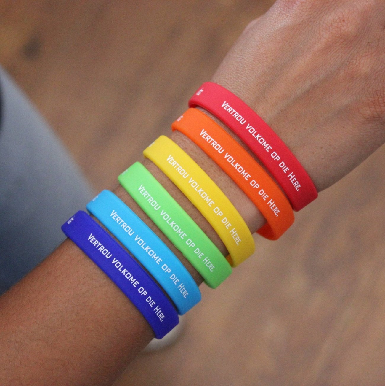 Colourful Christian Silicone Wristbands on a lady's arm - ITG Clothing